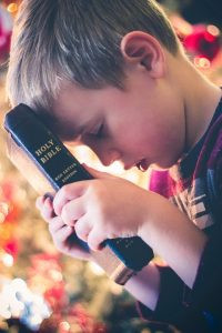 A child holding a bibleDescription automatically generated