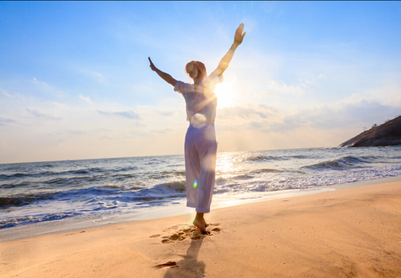 a woman standing on the beach with feeling of joy