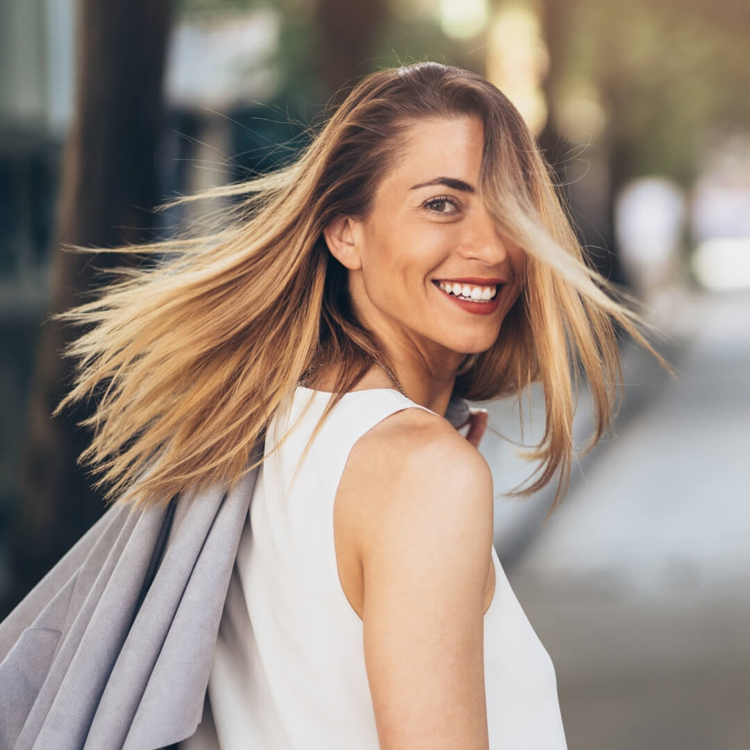  Confident smiling woman walking outdoors, symbolising freedom, energy, and transformation through hypnotherapy and menopause coaching in Brisbane.