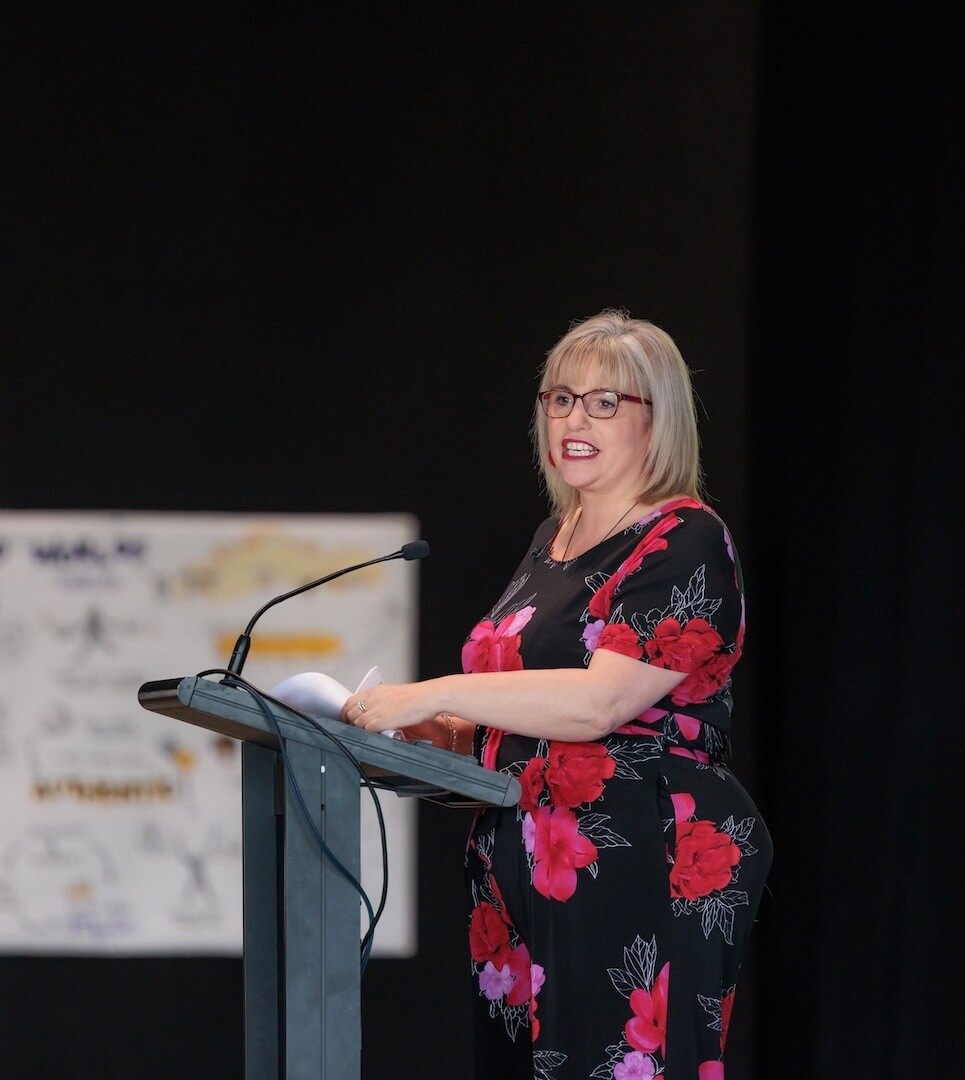  Women’s wellbeing speaker presenting at a UN Women Aotearoa New Zealand event, addressing an audience on burnout, leadership, and emotional resilience.