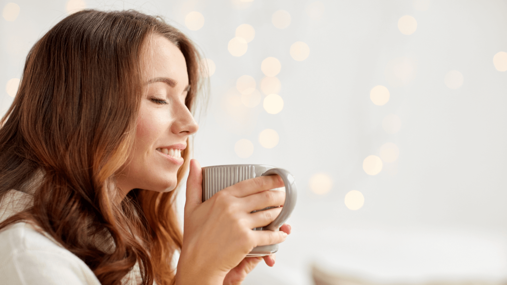  Relaxed woman peacefully enjoying a warm drink, symbolising nervous system calm and emotional relief.