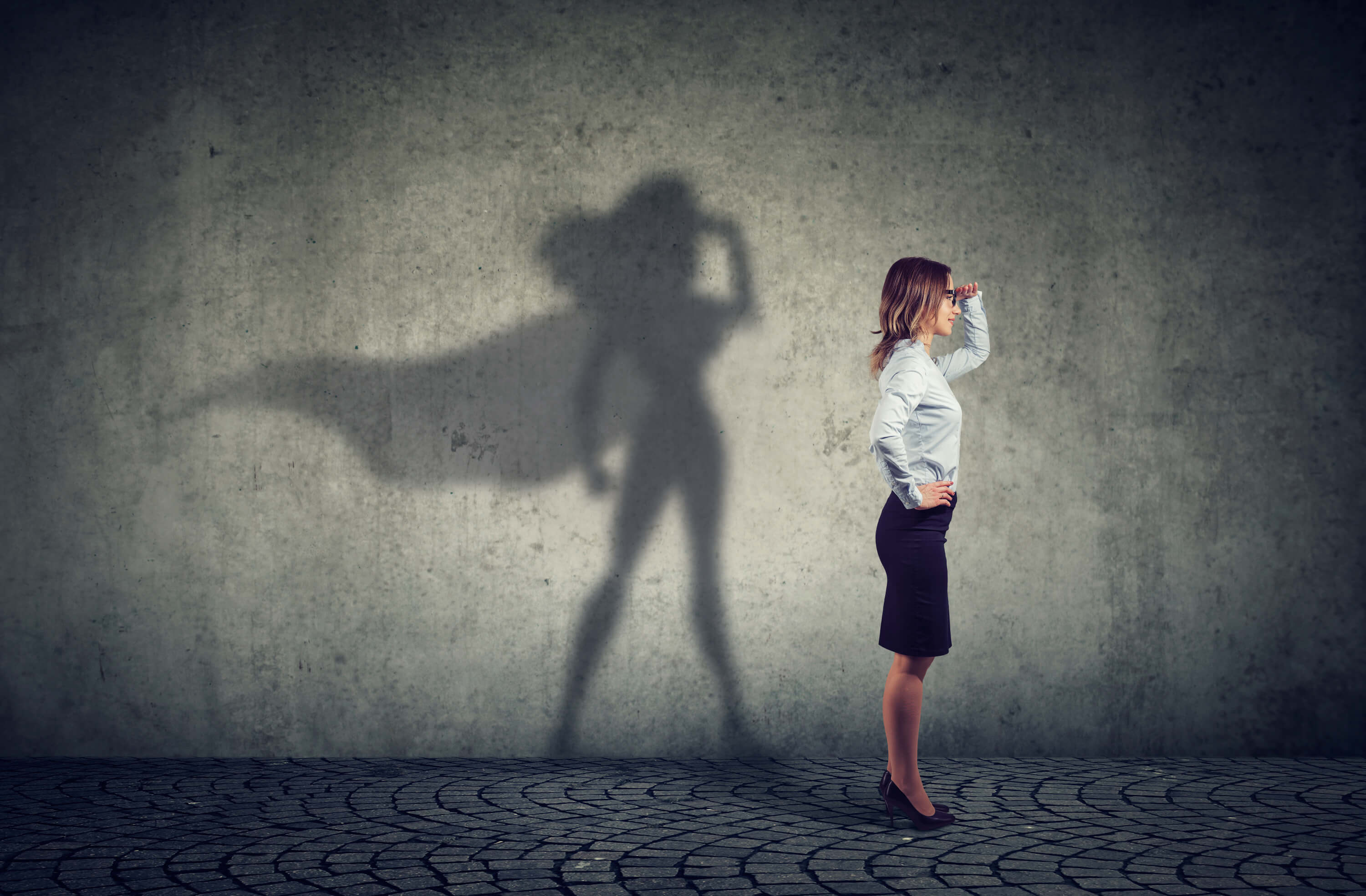 Image of a business woman casting a shadow with a cape